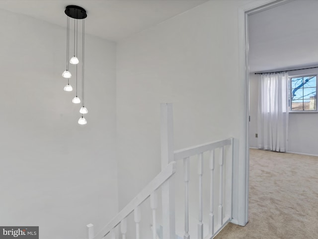 hallway featuring an upstairs landing and carpet floors