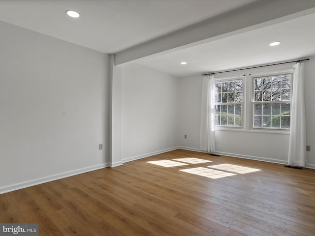 spare room featuring recessed lighting, baseboards, and hardwood / wood-style floors