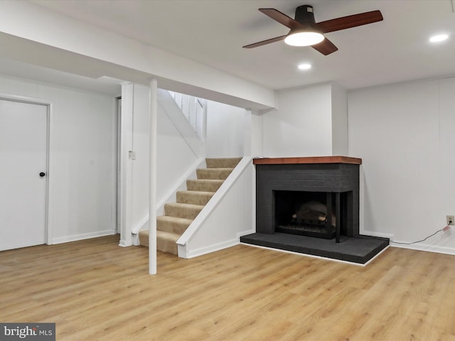 below grade area with ceiling fan, stairway, wood finished floors, and recessed lighting