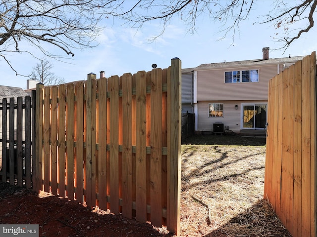 view of gate with cooling unit and fence