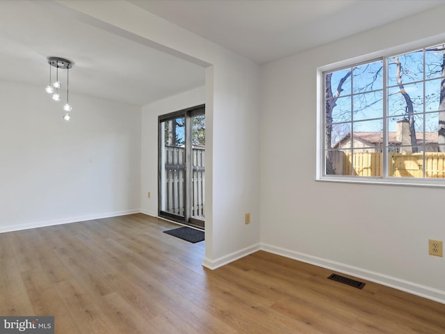 interior space with visible vents, baseboards, and wood finished floors