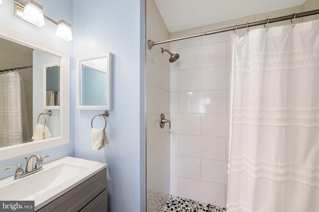 full bathroom with tiled shower and vanity