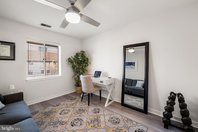 office space featuring wood finished floors, visible vents, and baseboards