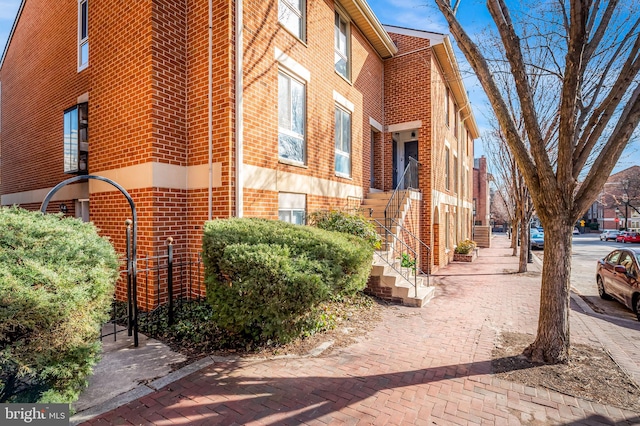 view of home's exterior featuring stairs and brick siding