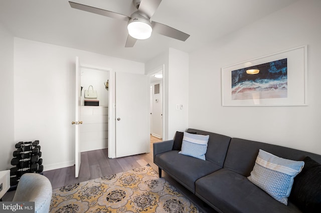 living room featuring ceiling fan, baseboards, and wood finished floors