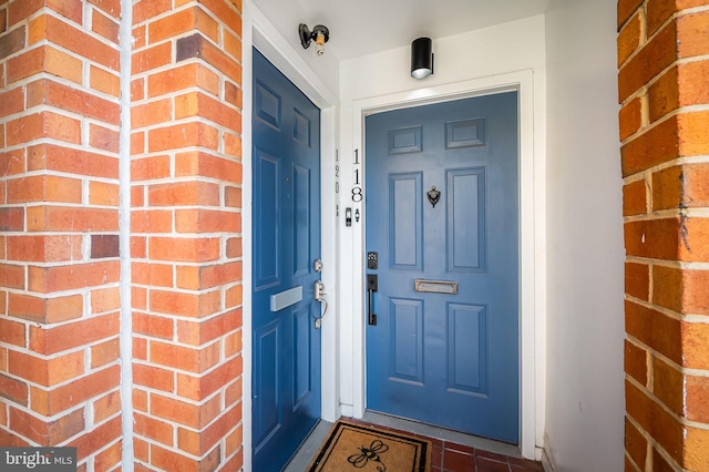 view of exterior entry with brick siding