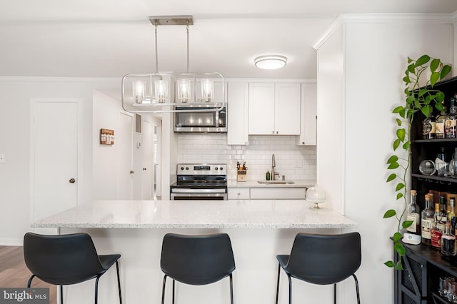 kitchen with backsplash, stainless steel electric range, a sink, and a kitchen bar