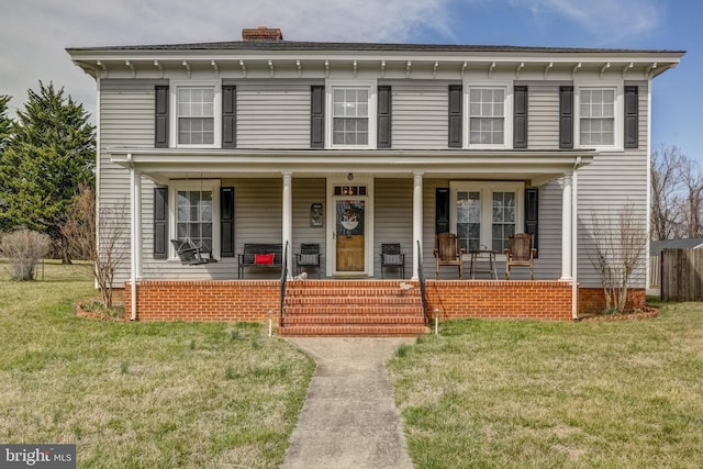 italianate house featuring a front lawn, covered porch, and a chimney