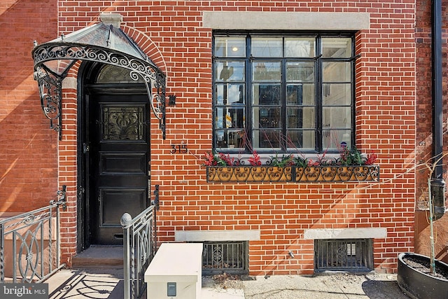 doorway to property featuring brick siding