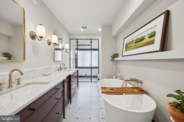 bathroom featuring double vanity, a shower stall, visible vents, and a sink