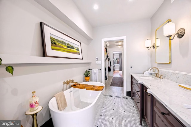 bathroom with recessed lighting, a freestanding bath, and vanity