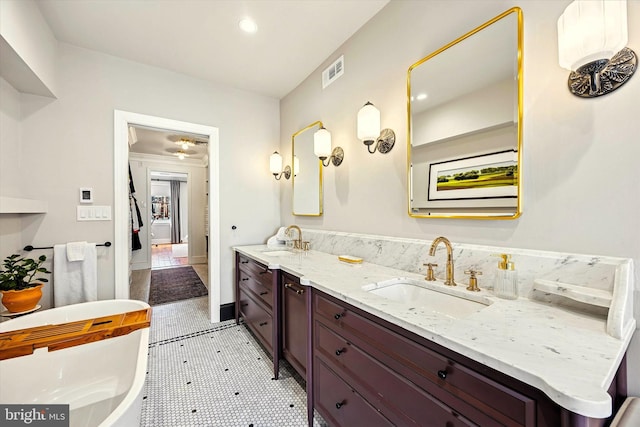 full bathroom with a soaking tub, visible vents, a sink, and double vanity