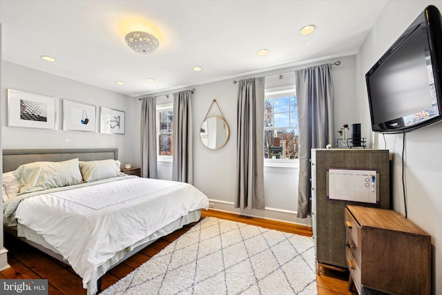 bedroom featuring baseboards, wood finished floors, and recessed lighting