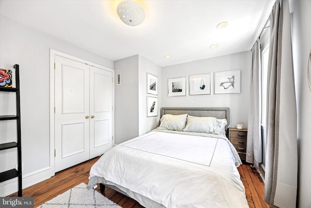 bedroom with a closet, wood finished floors, visible vents, and recessed lighting