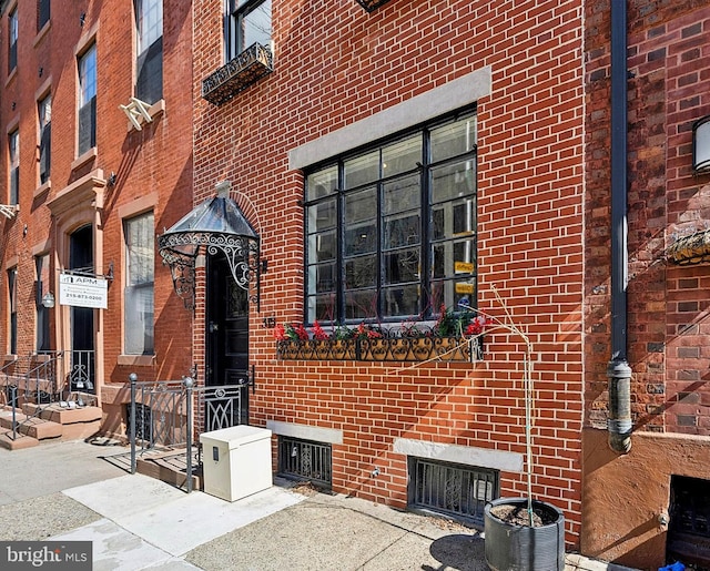 entrance to property featuring brick siding