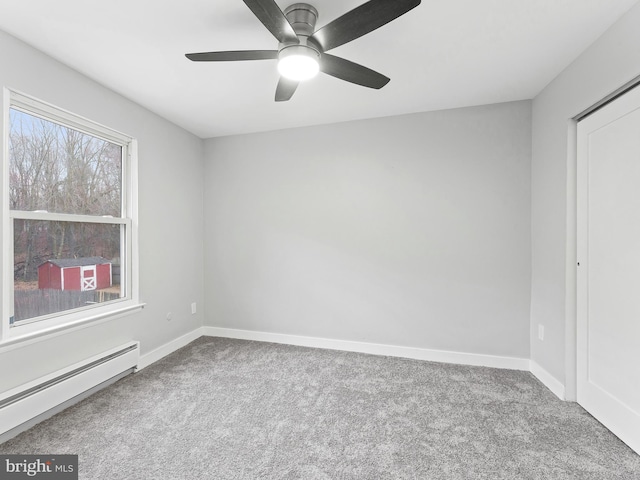 unfurnished bedroom with a ceiling fan, a baseboard radiator, carpet flooring, and baseboards