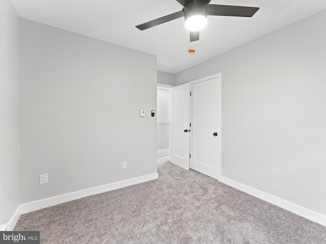 unfurnished bedroom with carpet, a ceiling fan, and baseboards