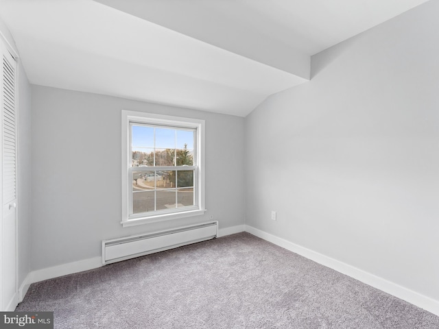 empty room featuring carpet floors, a baseboard radiator, lofted ceiling, and baseboards