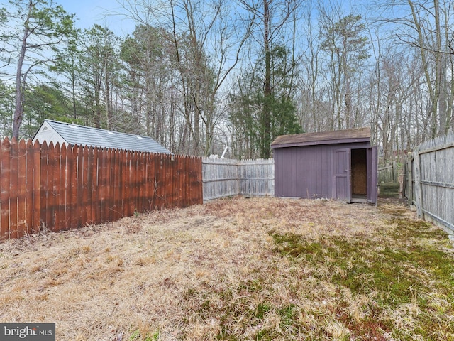 view of yard featuring a fenced backyard, an outdoor structure, and a shed