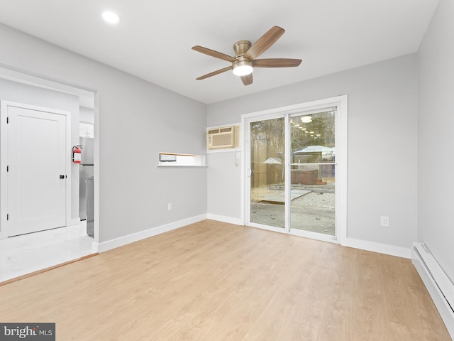 unfurnished room featuring baseboards, light wood-type flooring, a baseboard radiator, and a wall mounted air conditioner