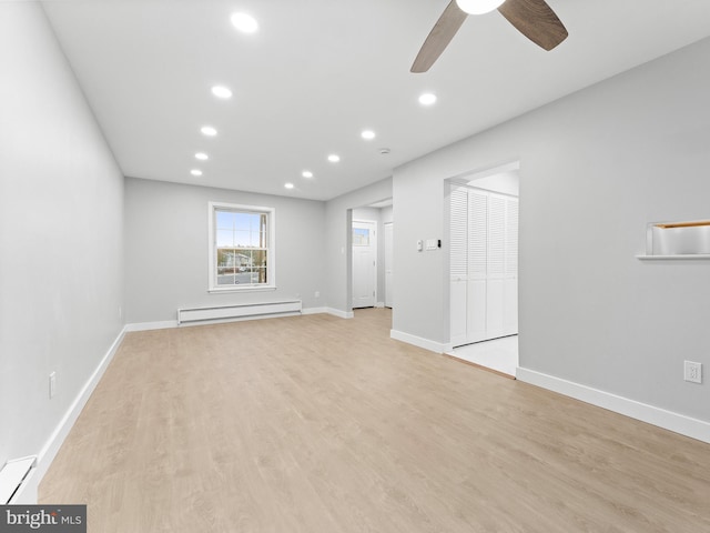 unfurnished living room featuring baseboards, baseboard heating, light wood-style floors, a baseboard heating unit, and recessed lighting