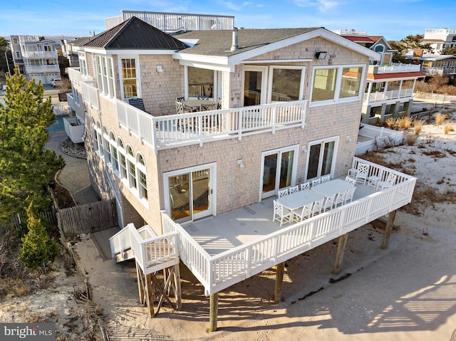 rear view of house with a balcony and fence