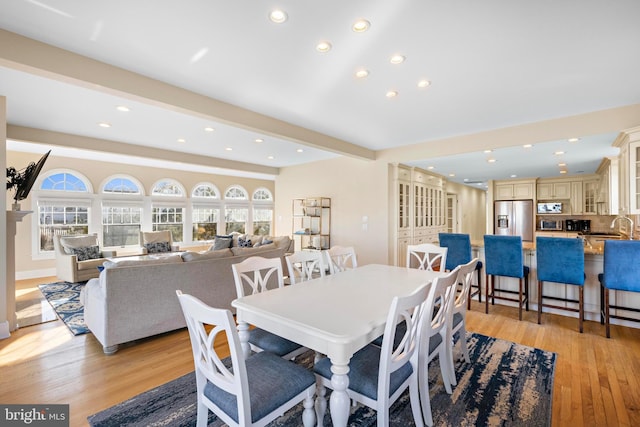 dining space with beamed ceiling, recessed lighting, and light wood-type flooring