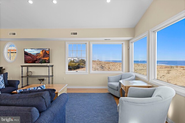 living area with visible vents, a healthy amount of sunlight, and wood finished floors