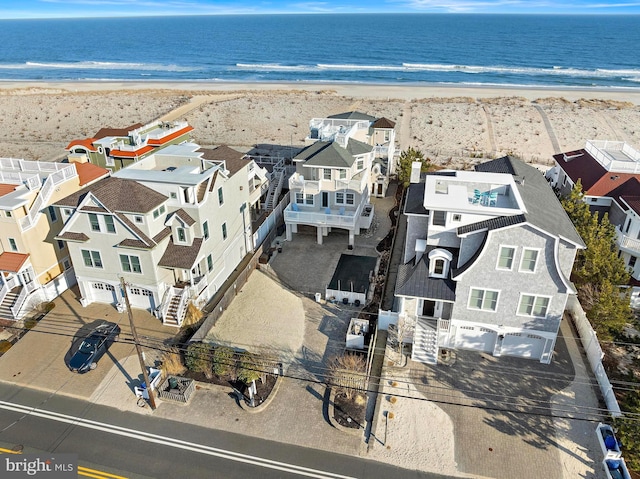 drone / aerial view featuring a residential view, a beach view, and a water view