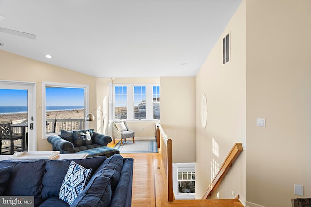 living room featuring visible vents, baseboards, lofted ceiling, recessed lighting, and wood finished floors