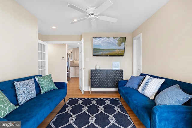 living area featuring wood finished floors and a ceiling fan