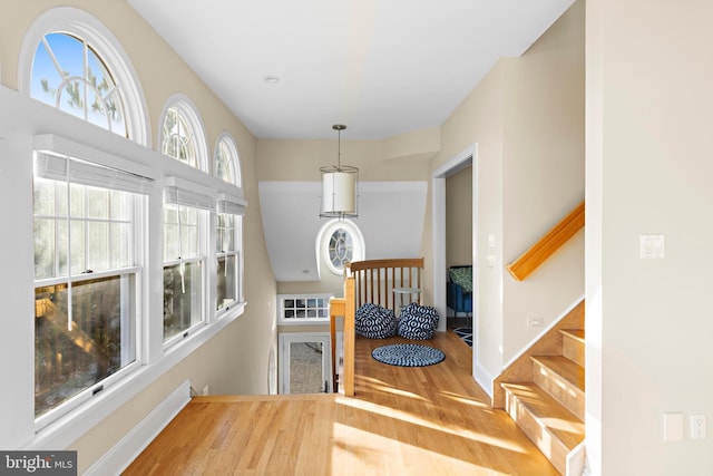 foyer entrance with baseboards, wood finished floors, and stairs