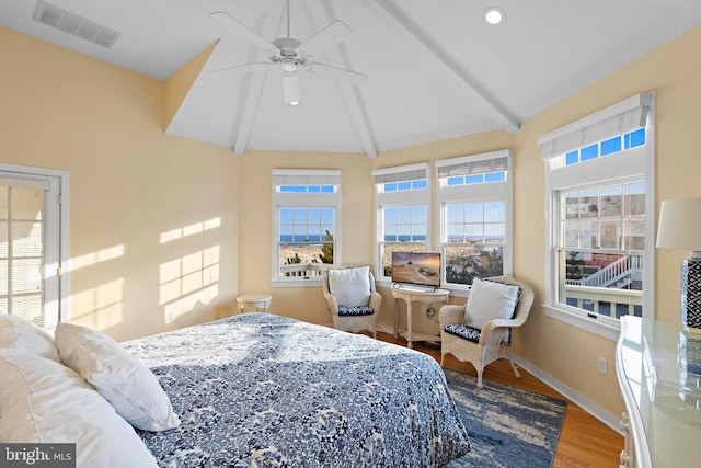 bedroom featuring a ceiling fan, wood finished floors, visible vents, baseboards, and lofted ceiling with beams