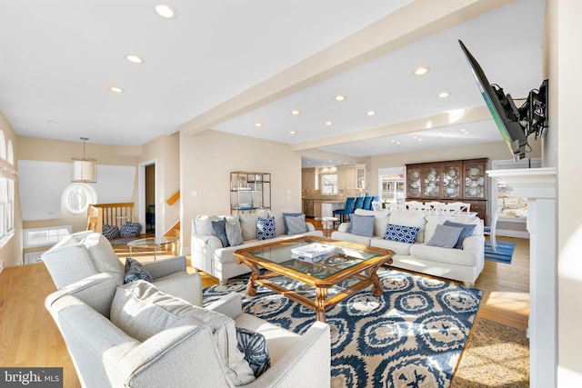 living room featuring beam ceiling, wood finished floors, recessed lighting, baseboards, and stairs