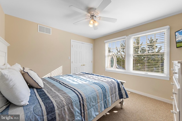 carpeted bedroom featuring baseboards, visible vents, a fireplace, ceiling fan, and a closet