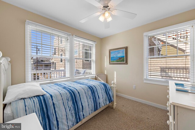 bedroom featuring a ceiling fan, multiple windows, carpet, and baseboards