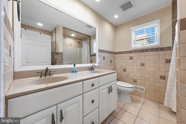 full bath with tile patterned flooring, tile walls, visible vents, and a sink