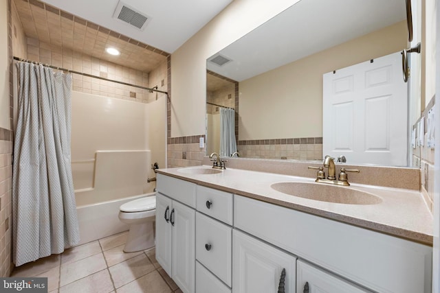 bathroom with double vanity, visible vents, tile patterned floors, and a sink