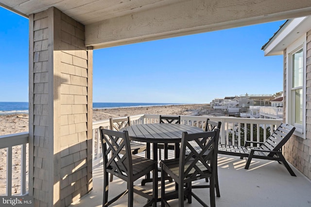 balcony featuring outdoor dining area and a water view