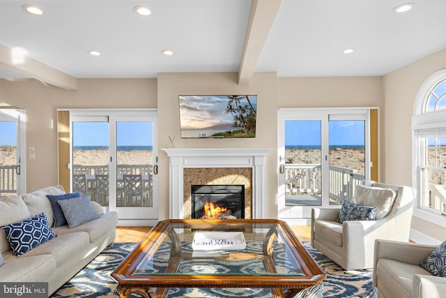 living area with beamed ceiling, recessed lighting, and a fireplace