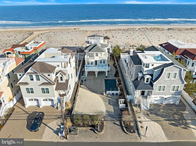 bird's eye view with a water view, a beach view, and a residential view