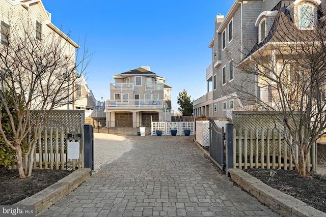 view of road with decorative driveway and a gate