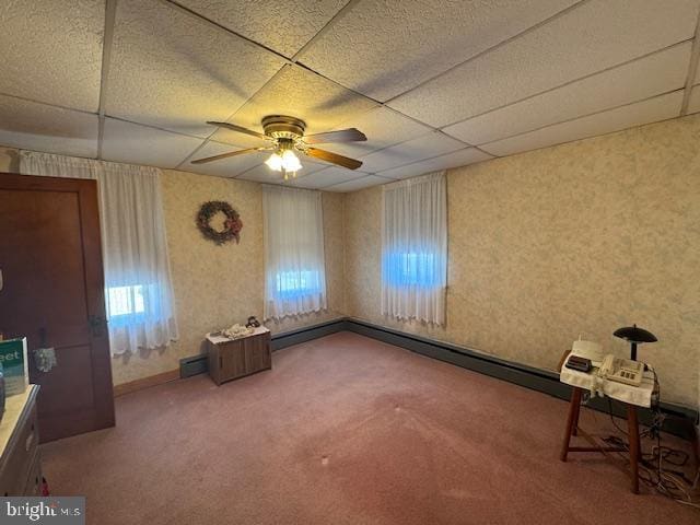 interior space with ceiling fan, carpet, a paneled ceiling, and wallpapered walls