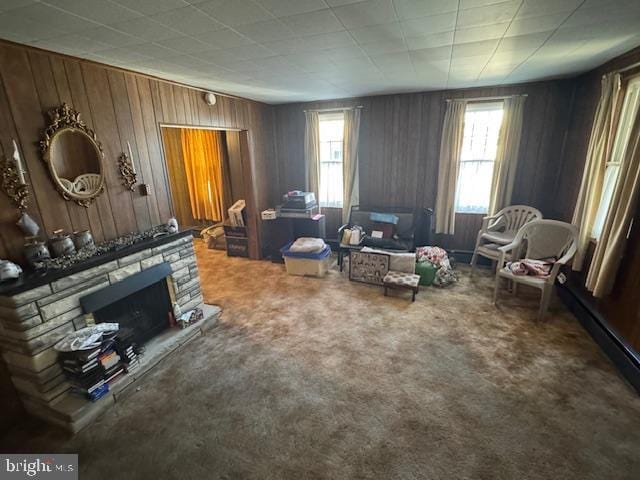 sitting room featuring carpet floors, wood walls, and a fireplace