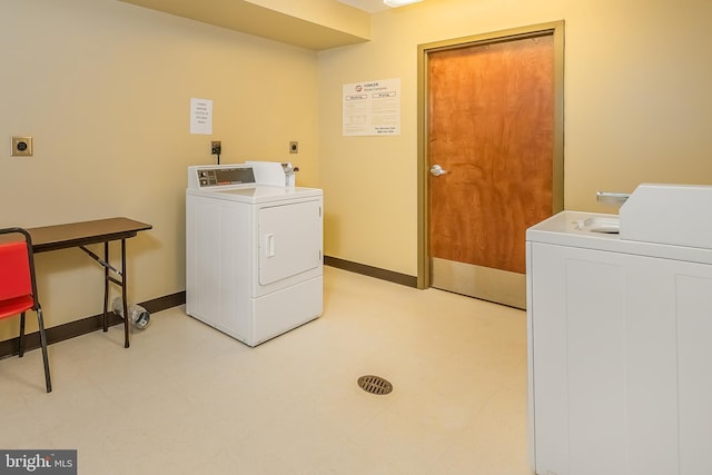 common laundry area featuring light floors, washing machine and dryer, and baseboards