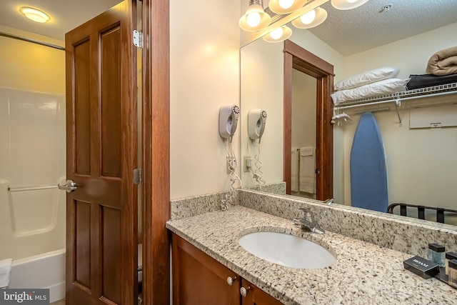 bathroom with a textured ceiling and vanity