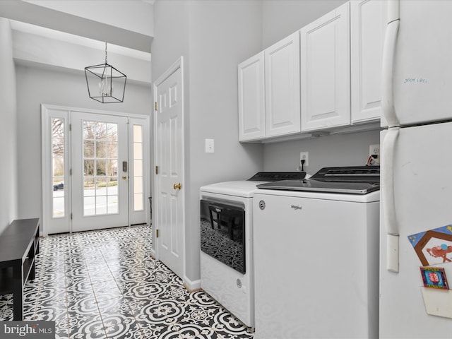laundry room with cabinet space, a notable chandelier, tile patterned floors, and washer and clothes dryer