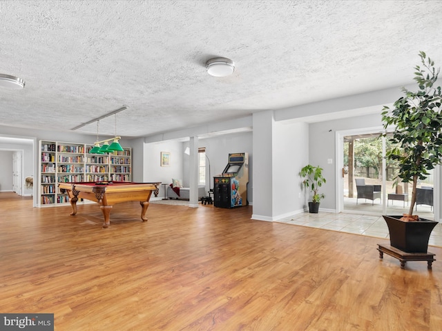 game room featuring billiards, baseboards, a textured ceiling, and light wood-type flooring