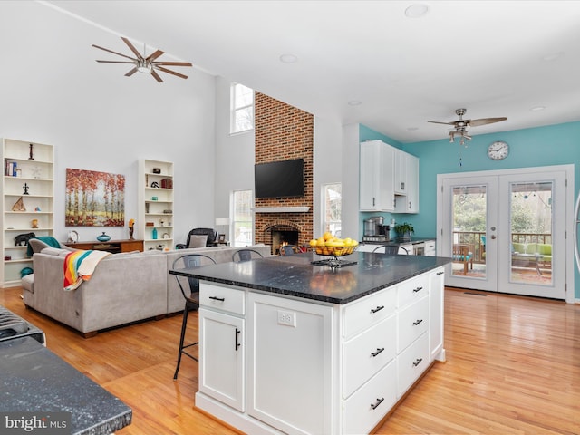 kitchen with a healthy amount of sunlight, open floor plan, light wood-style flooring, and a ceiling fan