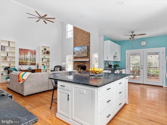 kitchen featuring light wood-type flooring, a healthy amount of sunlight, a ceiling fan, and open floor plan